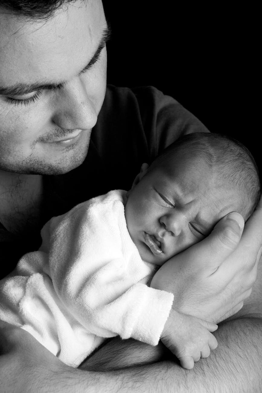 grayscale photo of man holding baby