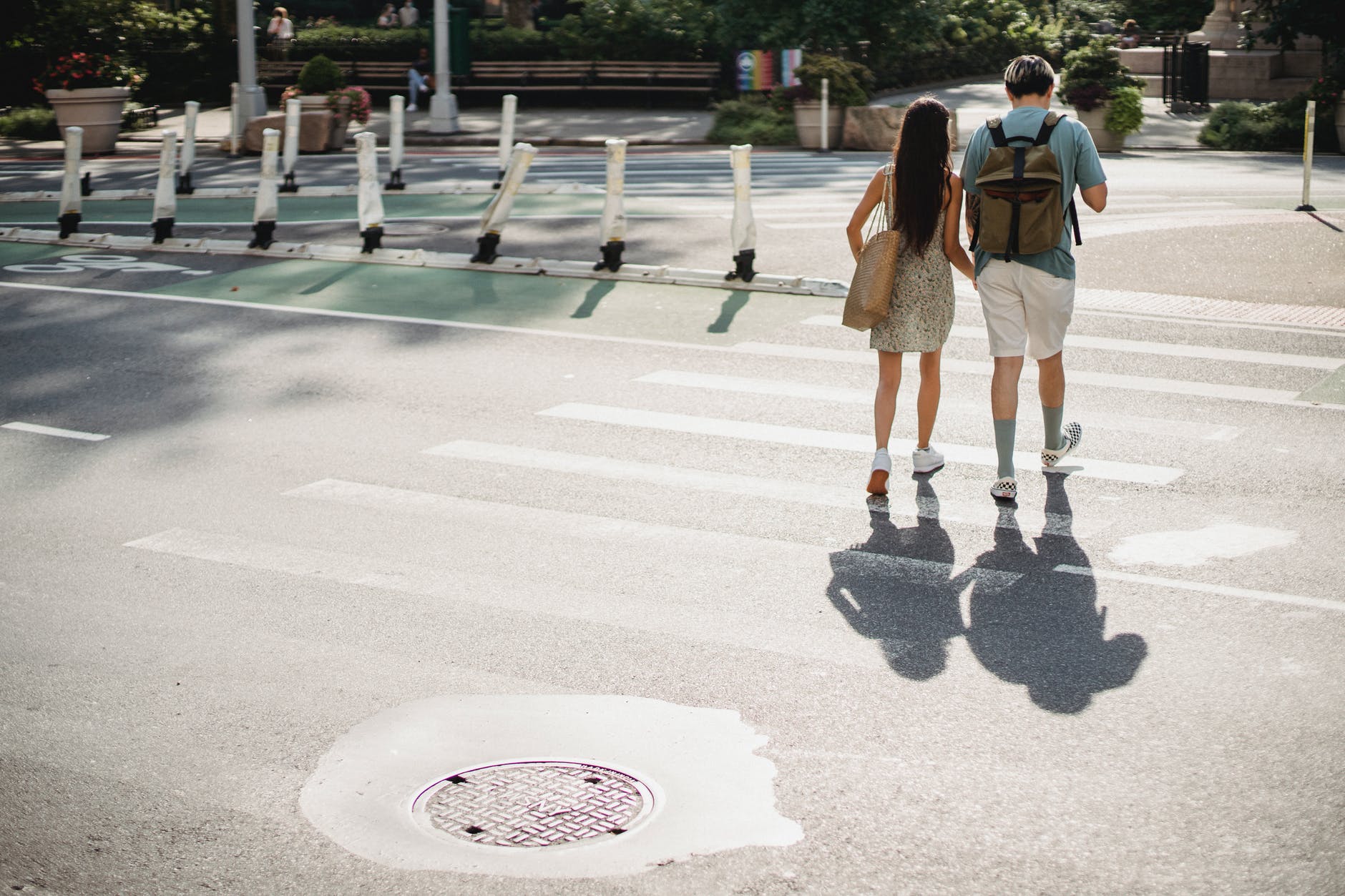 unrecognizable couple crossing road in sunny city